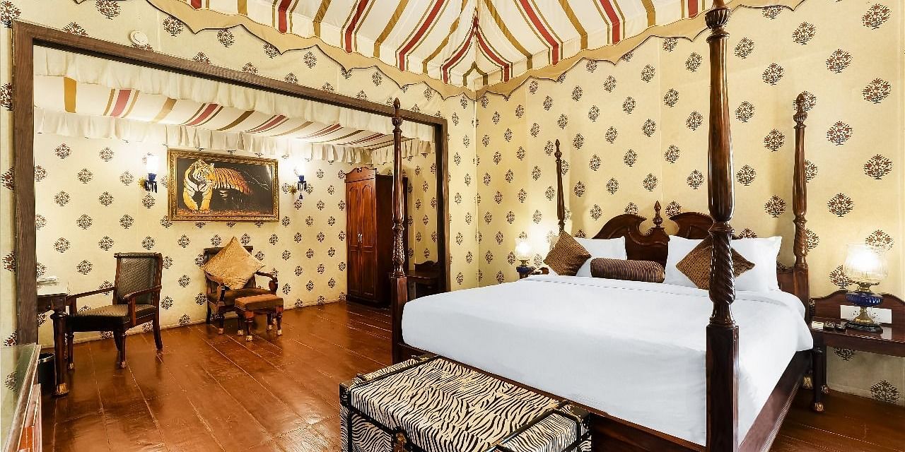 Opulent tented bedroom with four-poster bed and vintage decor at Rajasthali Resort Jaipur.