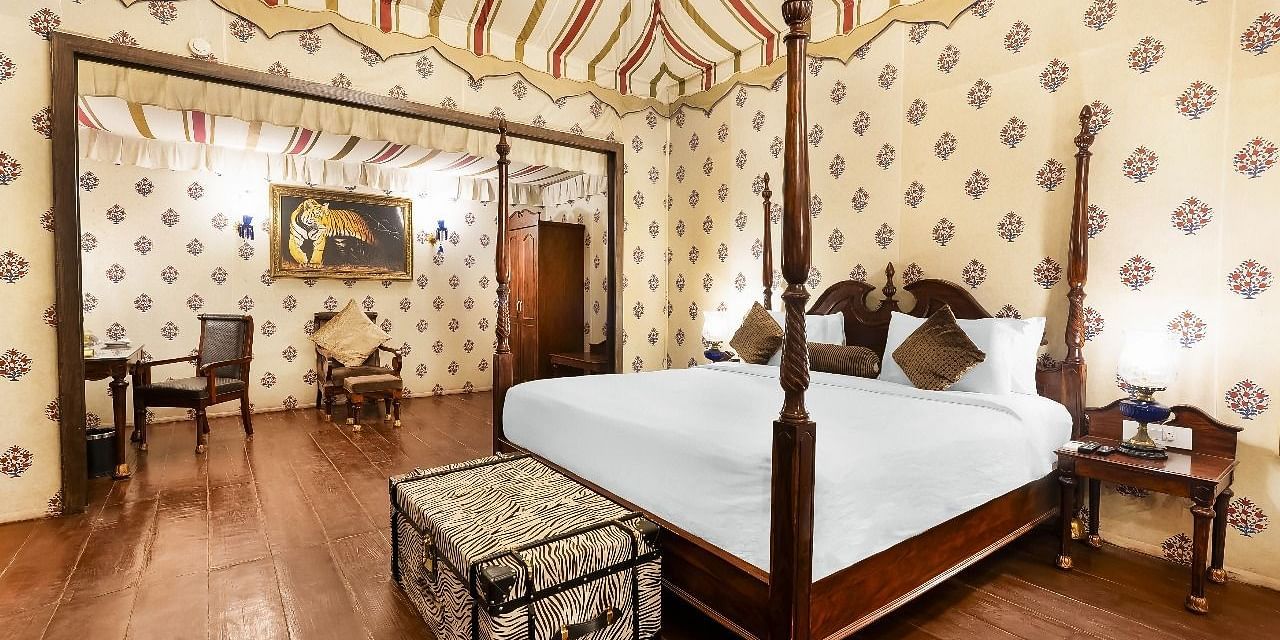 Spacious heritage tent bedroom with wooden furniture at Rajasthali Resort & Spa Jaipur.