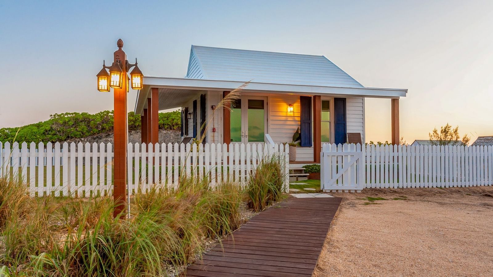 Entrance path leading to Hill Top Cottage at Abaco Inn with a picket fence and lantern.