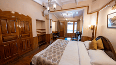 Side view of the Heritage Room with a cozy bed at Himalaya Hotel, Nainital
