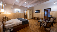 Corner view of room with bed and chairs at The Pavilion, Nainital