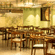 Restaurant interior with green walls, warm lighting and wooden tables and chairs at OJ Japanese Restaurant, Featherlite Evoma Hotel.