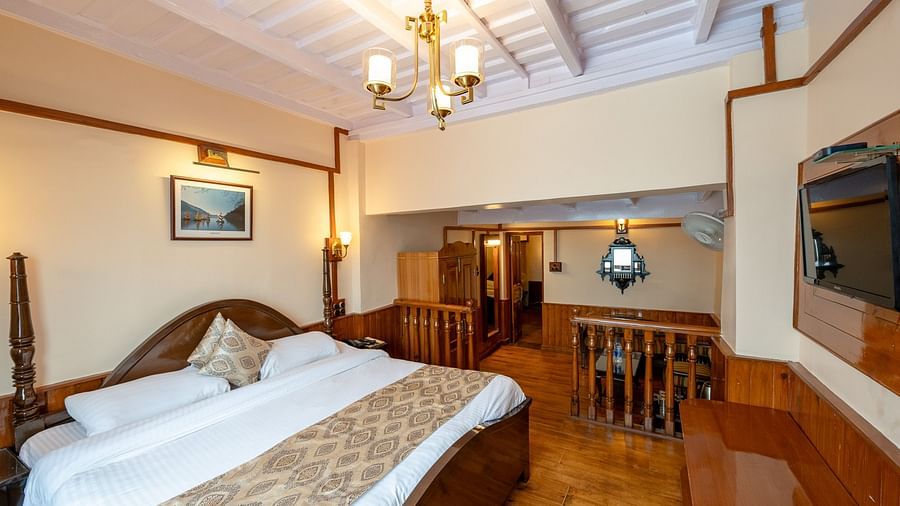 Side view of a cozy bed with stylish interior design in the Heritage Family Suite at Himalaya Hotel, Nainital