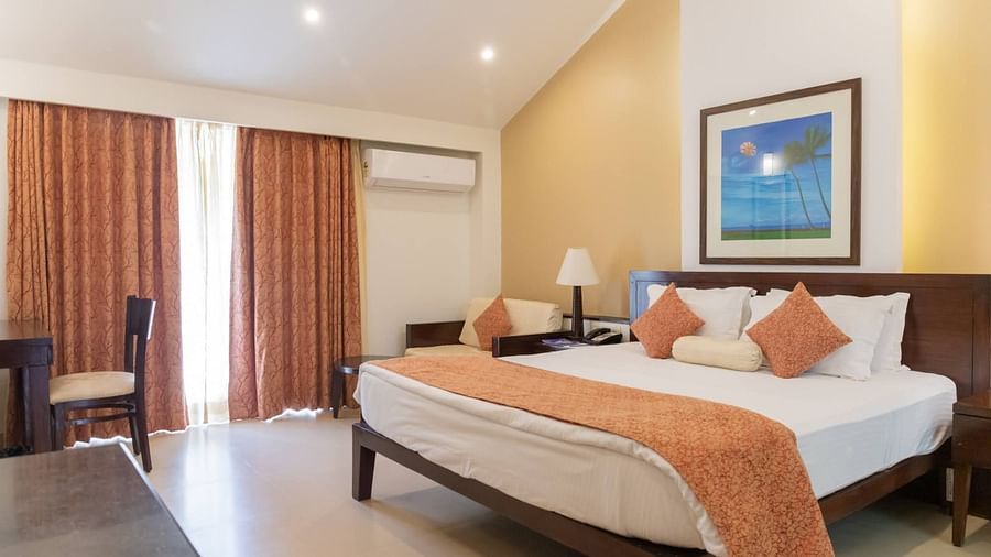 The king size bed in the premier room with peach coloured blanket at Kyriad Prestige Calangute, Goa