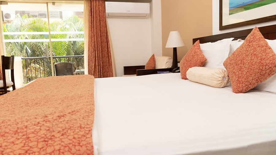 The king size bed in the premier room with peach coloured blanket at Kyriad Prestige Calangute, Goa