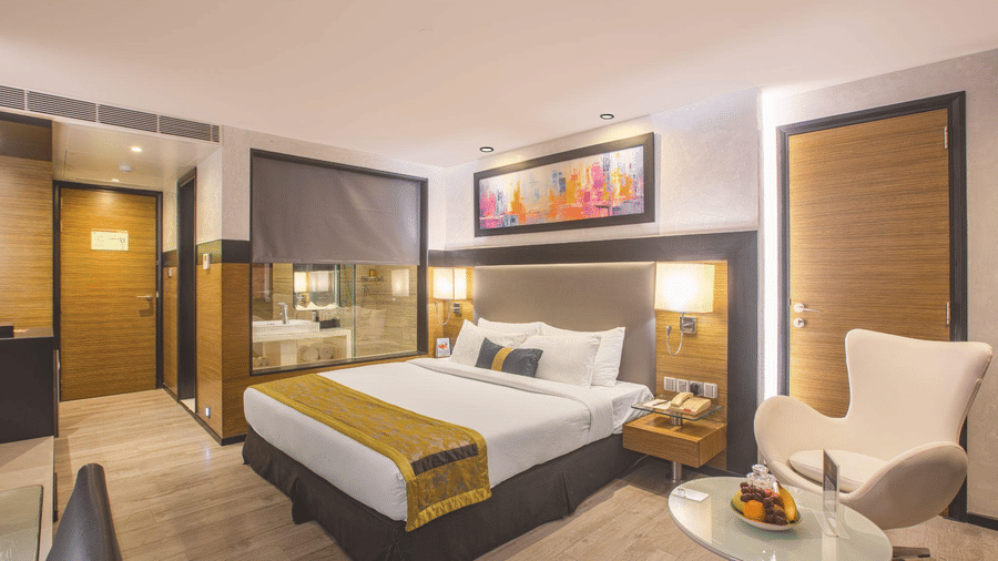 Modern guest room with plush king-size bed, elegant furnishings and contemporary amenities at The Empresa Hotel.