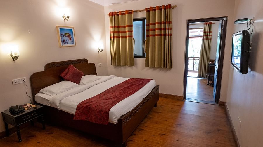 Side view of the bedroom with a cozy bed and bedside lights at The Pavilion, Nainital