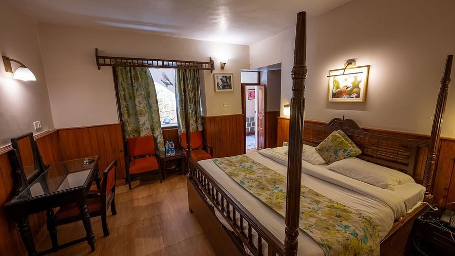 Spacious standard room with a cosy bed and a view from the window at The Pavilion, Nainital