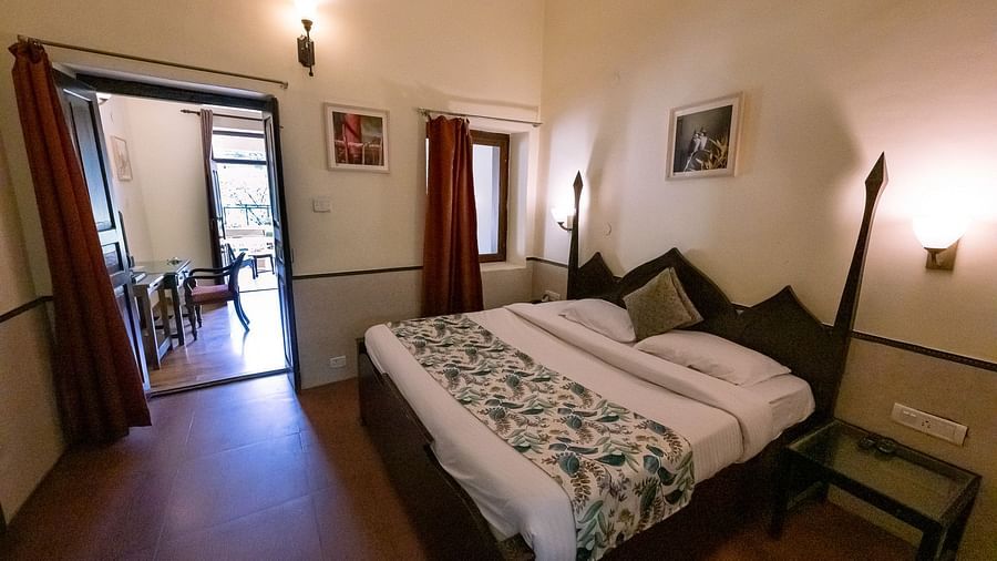 Side view of the bedroom with a cozy bed and bedside lights at The Pavilion, Nainital