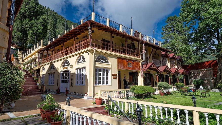 Pathway to the building entrance with lush greenery at The Pavilion, Nainital