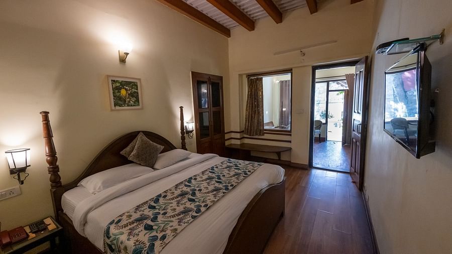 Side view of the bedroom with a cozy bed and bedside lights at The Pavilion, Nainital