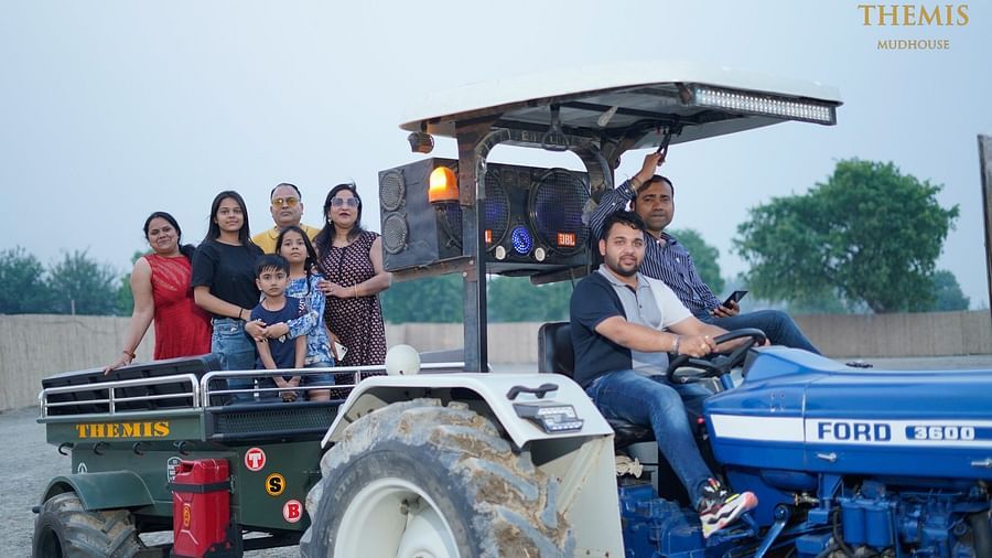 a group of people enjoying a tractor ride at Themis Mudhouse - A Nature's Retreat Resort & Wellness