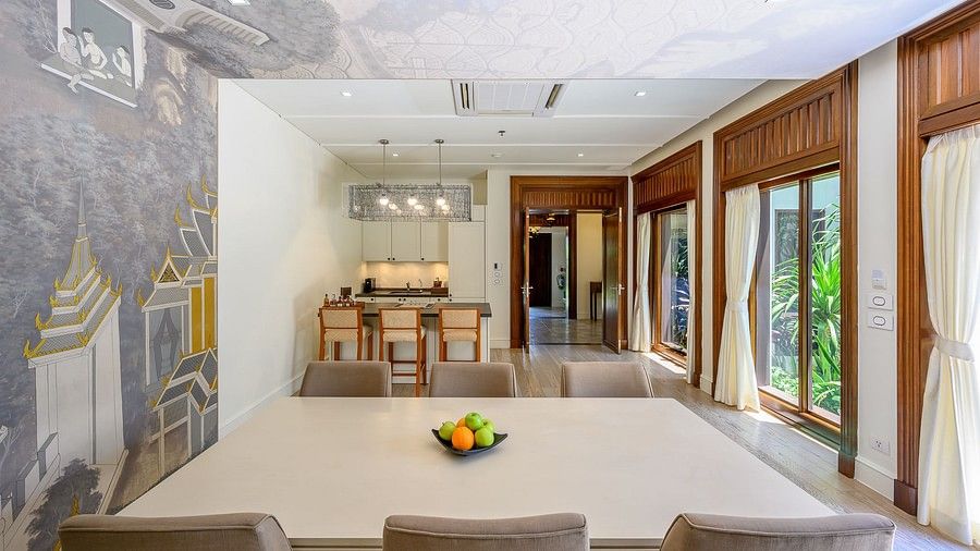 image featuring an empty dining table with a kitchenette at the far corner - one bedroom private pool beachfront villa