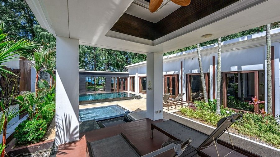 image featuring two chairs facing the swimming pool under a shade - one bedroom private pool beachfront villa