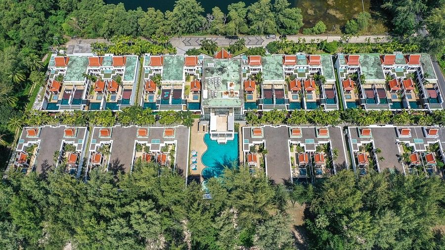 full view of the maikhao dream villa resort in phuket surrounde by talk palm trees