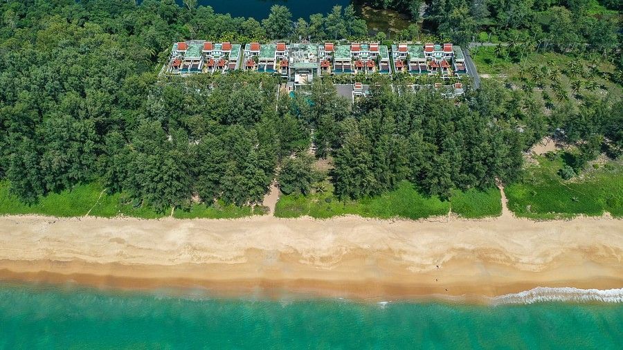 image of the beach with crystal clear waters right in front of maikhao dream villa resort in phuket