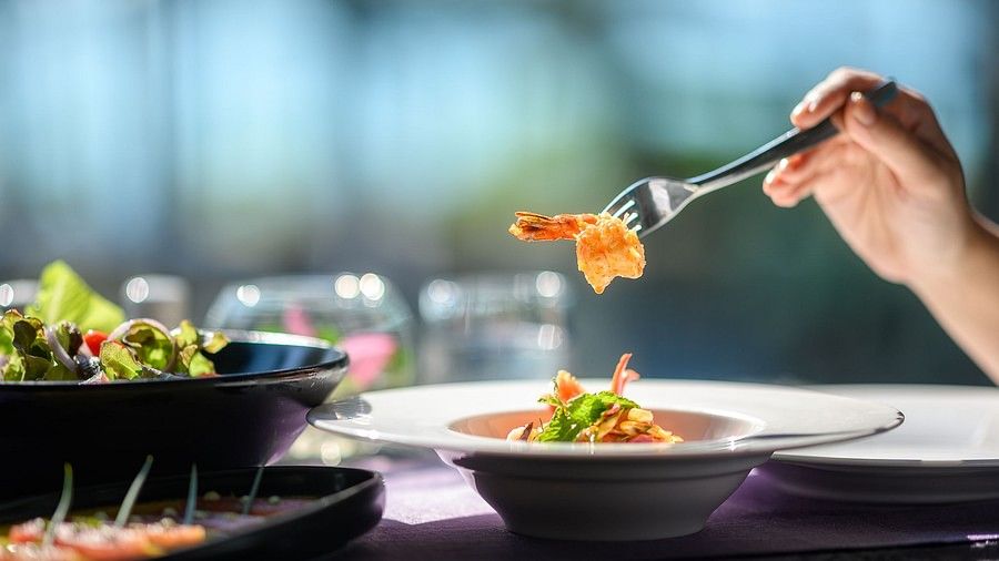image of a person picking up food with the help of a fork - Maikhao Dream Villa Resort & Spa, Phuket