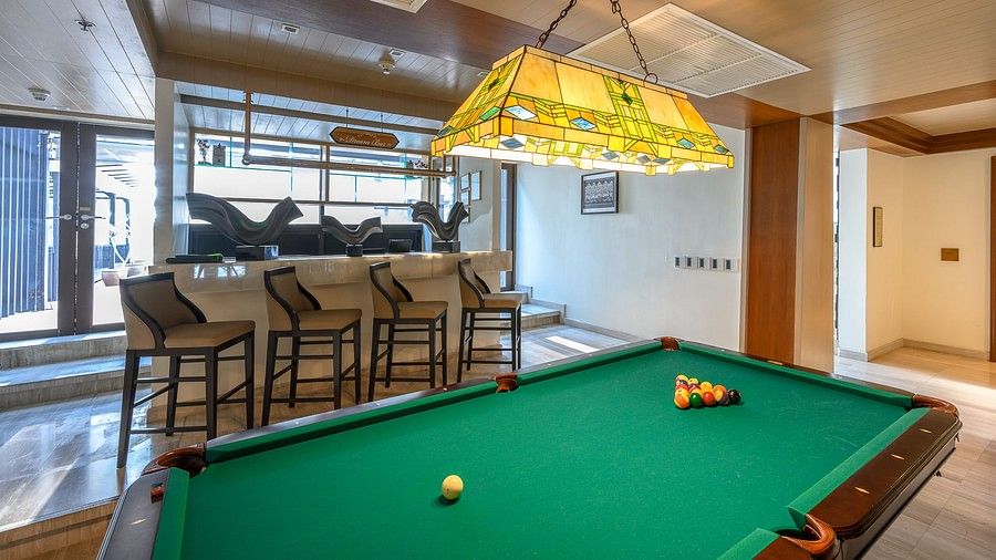 image of green coloured pool table with chairs lined up behind it at maikhao dream villa resort and spa, phuket