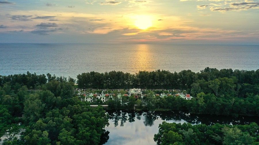 image of a serene sun setting in the calm waters - maikhao dream villa and spa, phuket