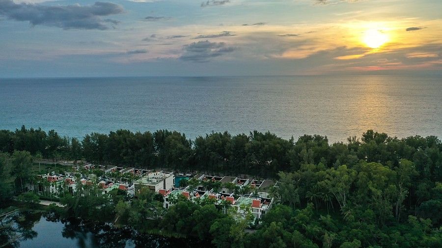 an aerial image featuring a mesmerising sunset with maikhao dream villa resort and spa in the foreground