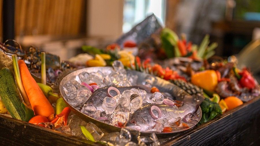 a close up image of a plate with two raw fishes topped with sliced onion rings - Maikhao Dream Villa Resort & Spa, Phuket