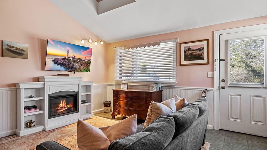 Living room with fireplace, flat screen TV, and large window at Hartstone Inn