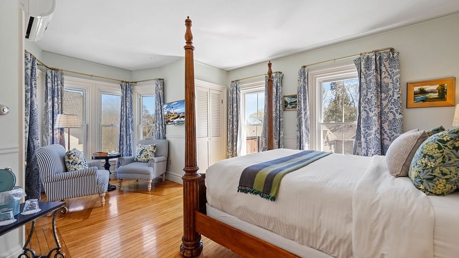Elegant room with glass windows and dark wood four-poster bed at Hartstone Inn