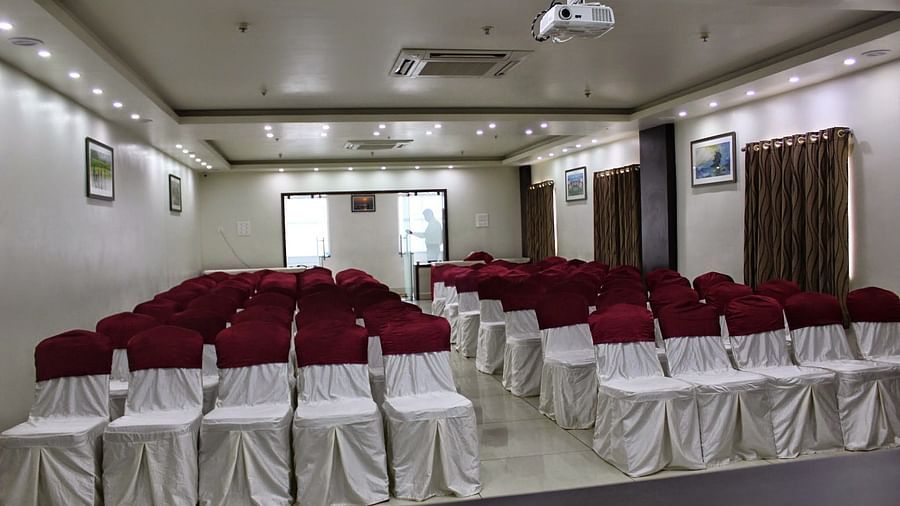 Jyothi hall with seats arranged and lights on the ceiling at Hotel Green Apple