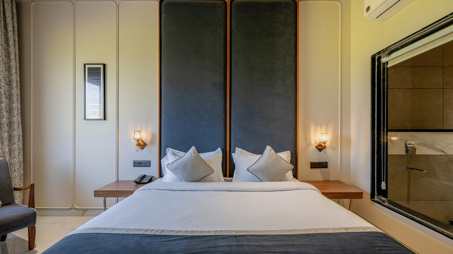King bedroom at Hotel Highway Prince, Behror with a white bed, tall dark headboards, and a window overlooking the local landscape.