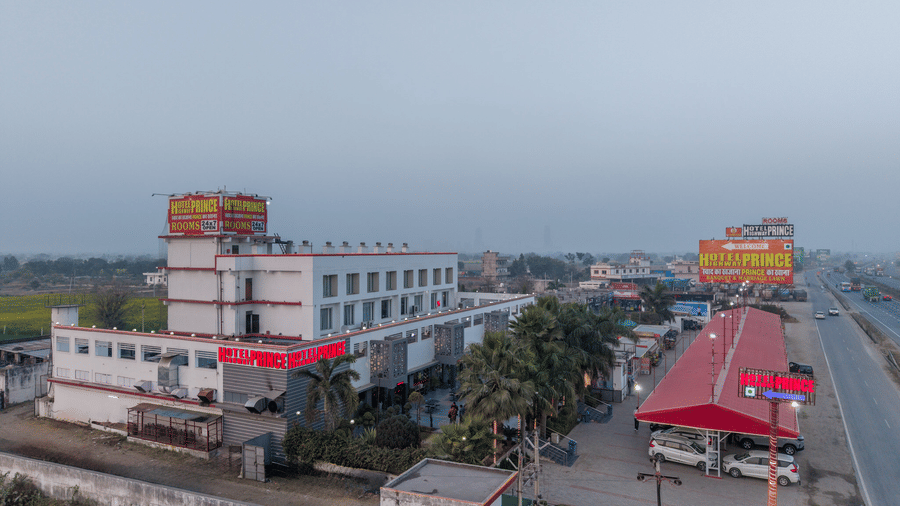 Hotel Highway Prince Paota drone view of hotel building along highway with red canopy, billboard signage, and misty morning atmosphere.