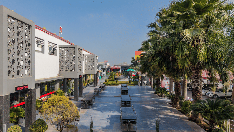 Hotel Highway Prince Paota exterior street view with decorative facade, palm trees, open driveway, and clear daytime sky.