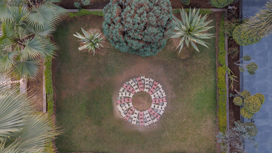 Hotel Highway Prince Paota top-down aerial view of manicured circular garden with decorative pattern, surrounded by lush green hedges and trees.