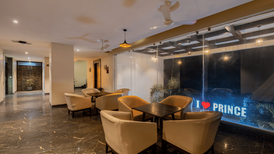 Hotel Highway Prince Paota cozy lounge area with beige cushioned armchairs, mood lighting, and illuminated I Love Prince feature wall.
