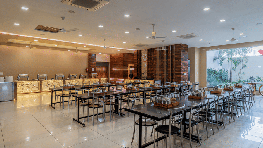 Hotel Highway Prince Paota spacious restaurant interior with neatly arranged dining tables, bright lighting, large windows, and clean modern decor.