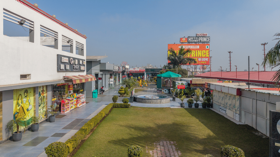 Hotel Highway Prince Paota rooftop terrace view overlooking highway, open landscape, green fields, and surrounding commercial structures.
