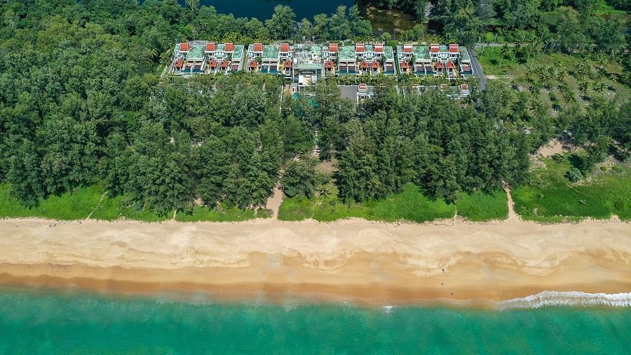 image of the beach with crystal clear waters right in front of maikhao dream villa resort in phuket