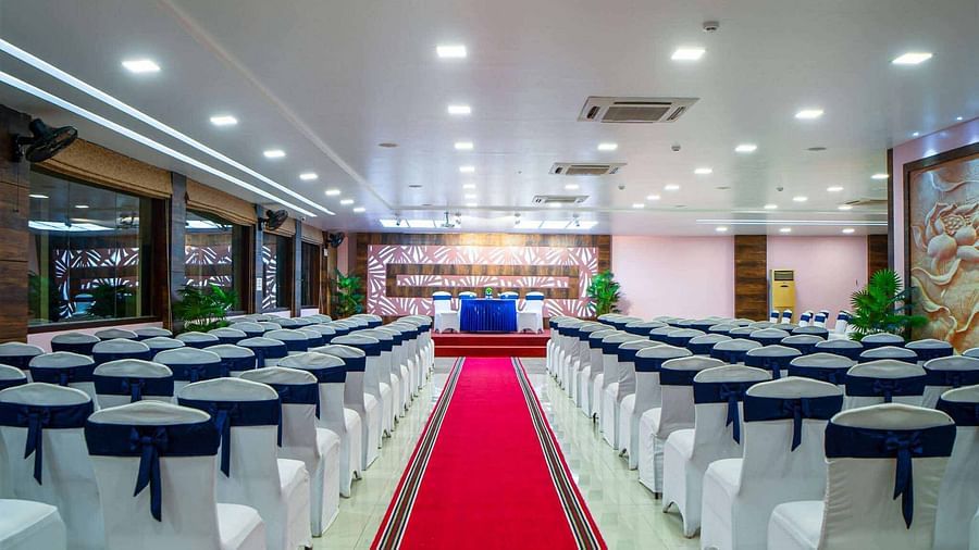 An event room at Mansha Hotel Regency set up with rows of chairs facing a stage, with a red carpet down the aisle.