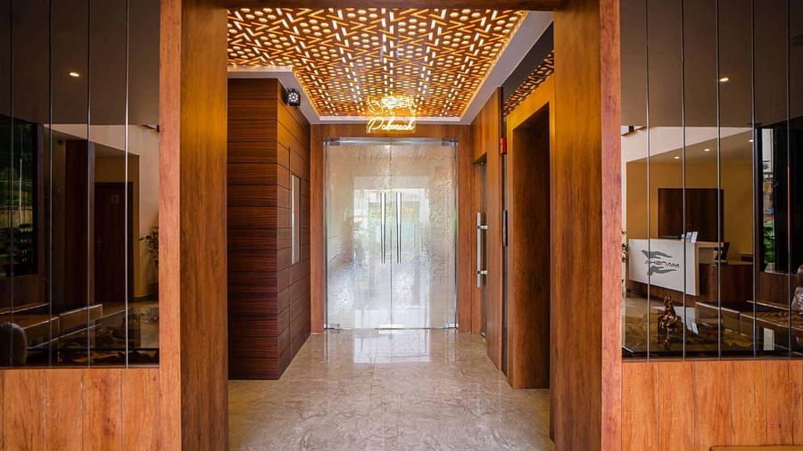 The elegantly designed entryway of Mansha Palace features wooden accents, mirrors, and warm lighting.
