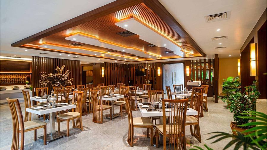 The inviting dining area at Mansha Palace features neatly arranged tables and comfortable wooden chairs.