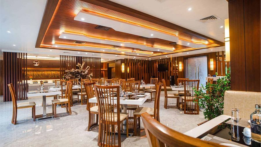 The inviting dining space at Pakeezah Restaurant, Mansha Palace features elegantly set tables and comfortable wooden seating.