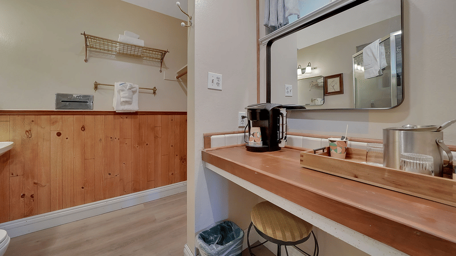 A coffee machine on a table placed besides a tray with a mug and creamer - Narrow Gauge Inn - A Serenite Hotel Near Fish Camp.