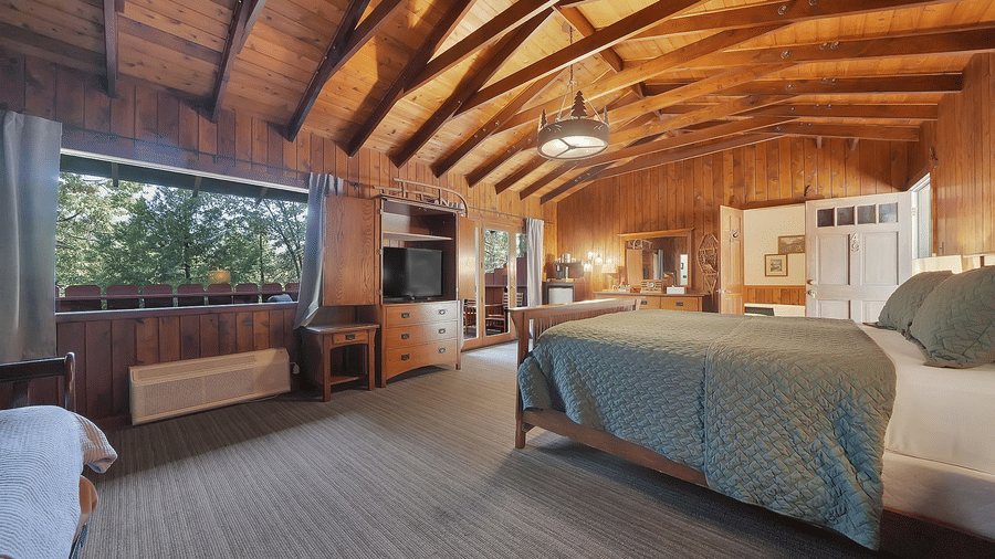 A view of a room at Narrow Gauge Inn with a double bed and wooden interiors.
