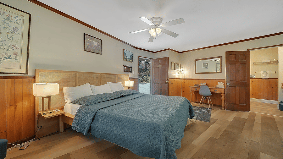 A view of a room at Narrow Gauge Inn with a double bed and side tables with table lamps.