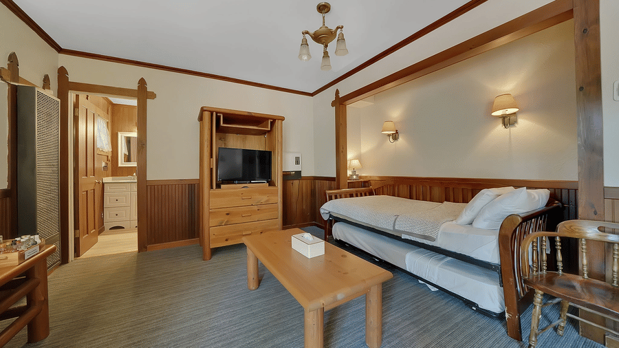 Living room area of a room at Narrow Gauge Inn with a cabinet and a couch.