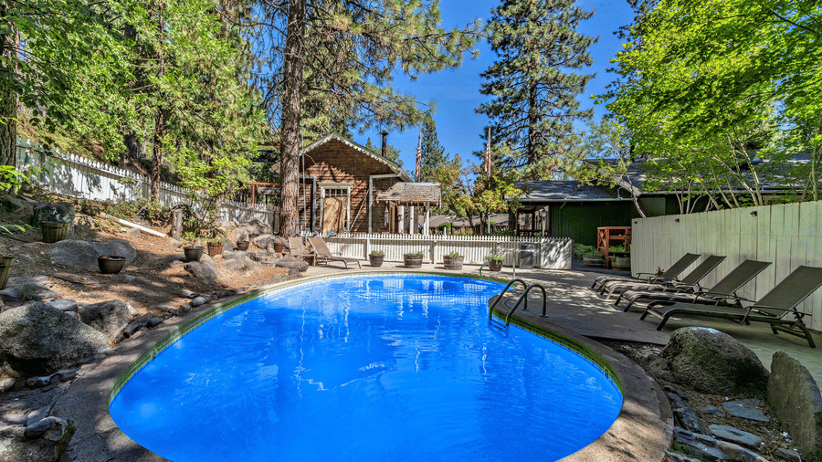 Outdoor swimming pool area at Narrow Gauge Inn surrounded by trees.