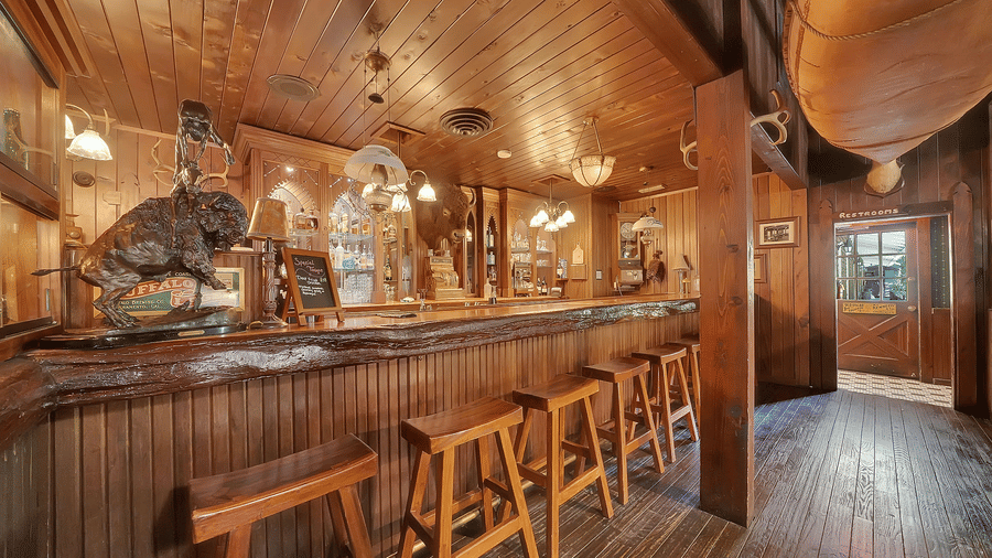 Bar counter seating area in a restaurant at Narrow Gauge Inn with a wooden theme.