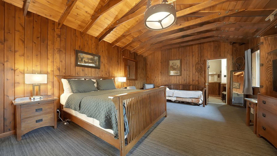 A view of a room at Narrow Gauge Inn with a double bed and wooden interiors.