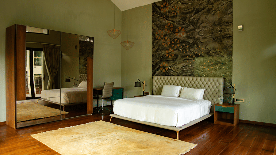 A bedroom at Stanley Leisure with a white bed, floral wall art, and high ceiling with exposed beams.
