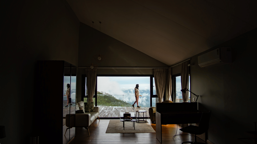 A wide shot of a bedroom at Stanley Revelation with a panoramic view of the mountains from a balcony.