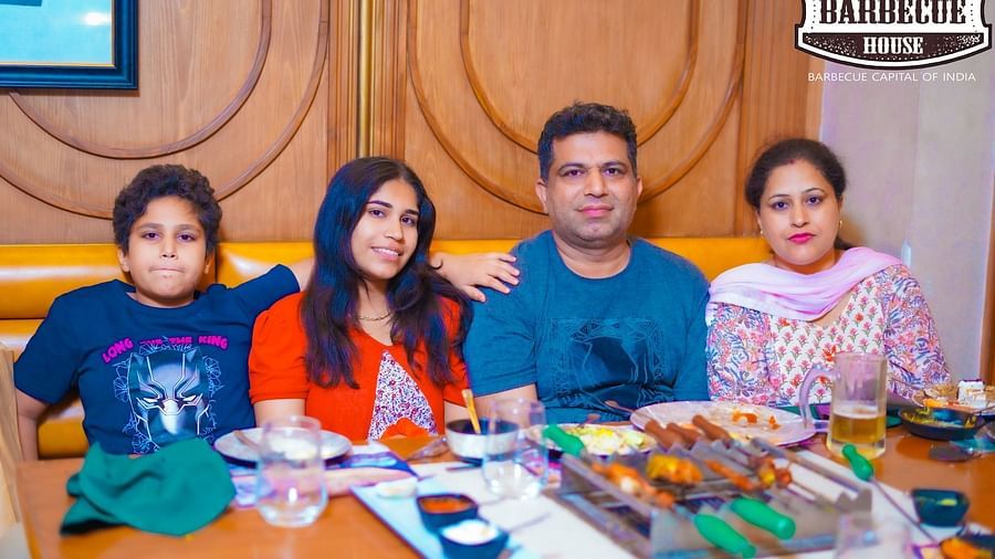 An image of a family sitting on a dining table at Themis Barbecue House, Panipat